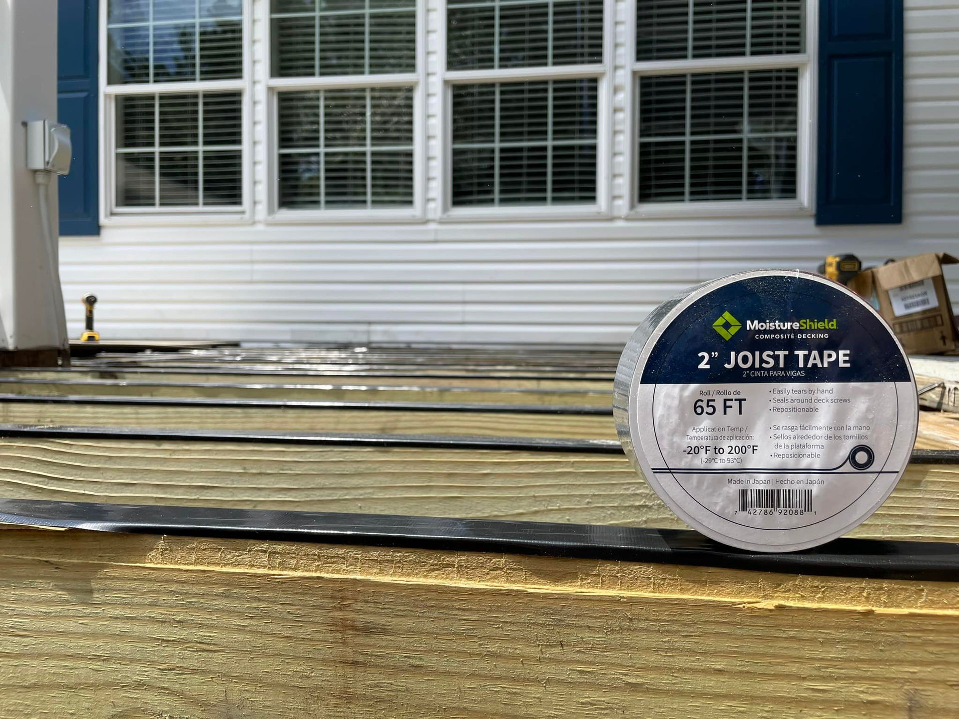 A roll of tape is sitting on the ground in front of a house.