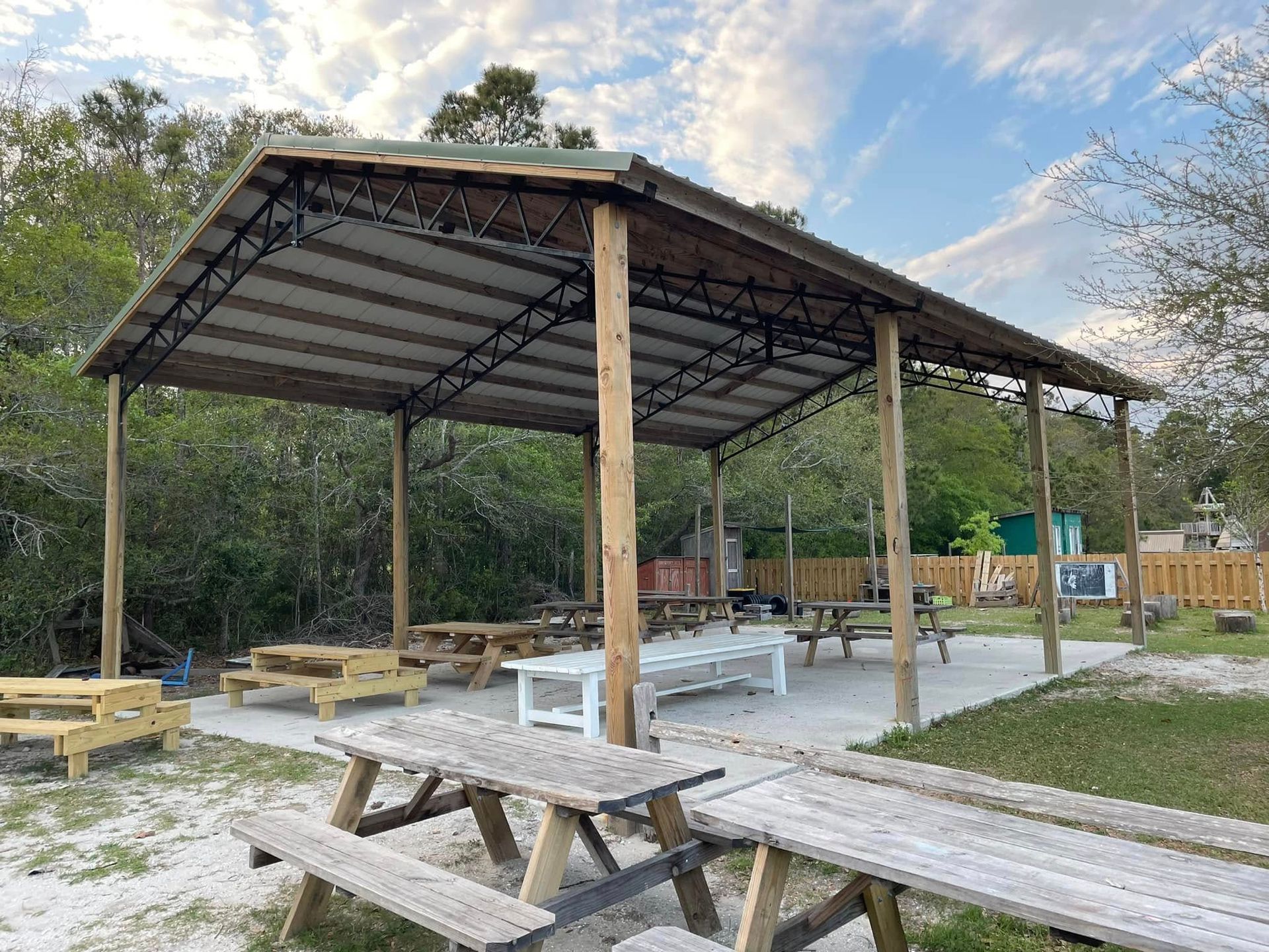A picnic area with tables and benches under a covered shelter.