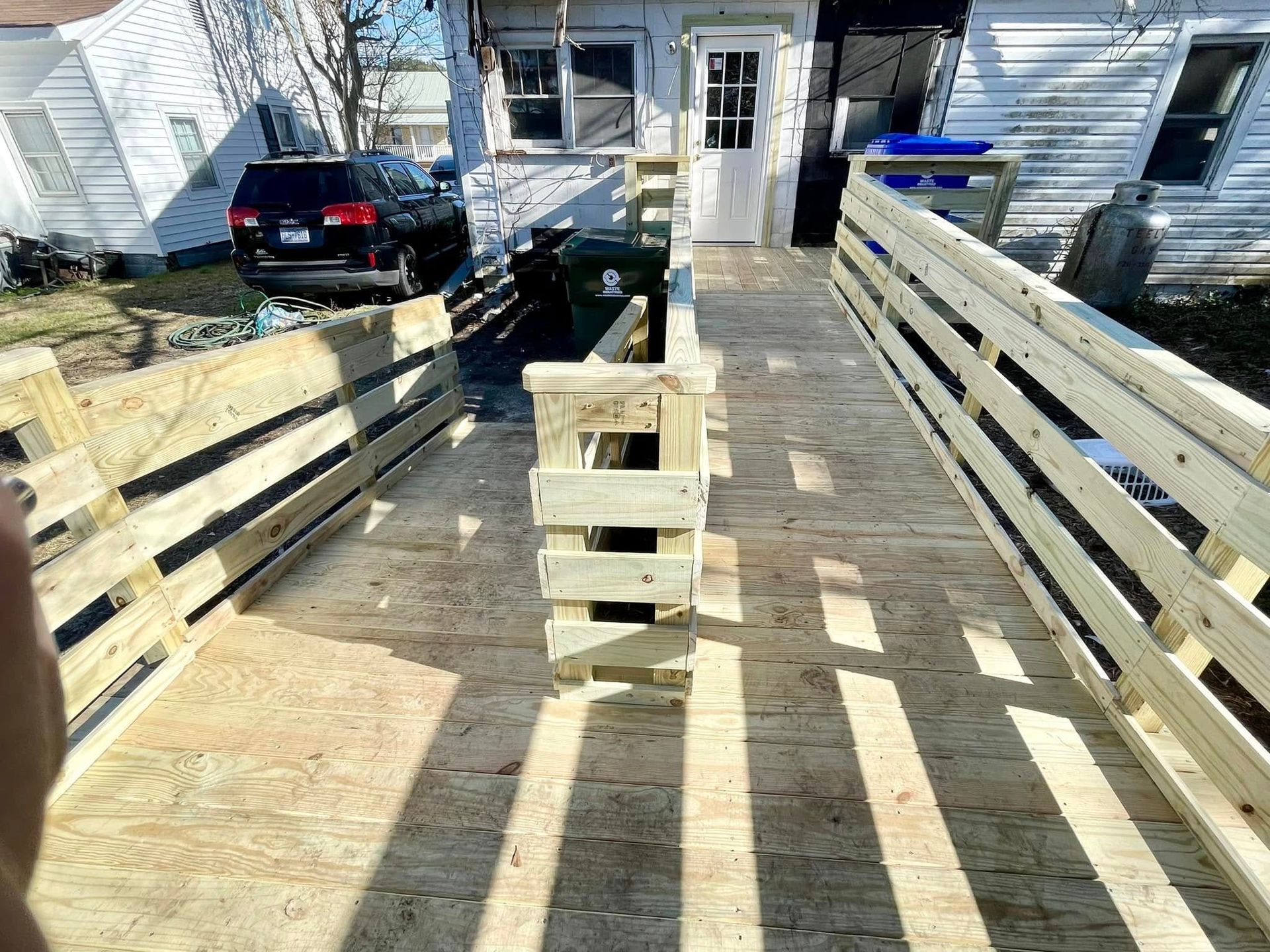 A wooden deck with stairs leading up to a house.