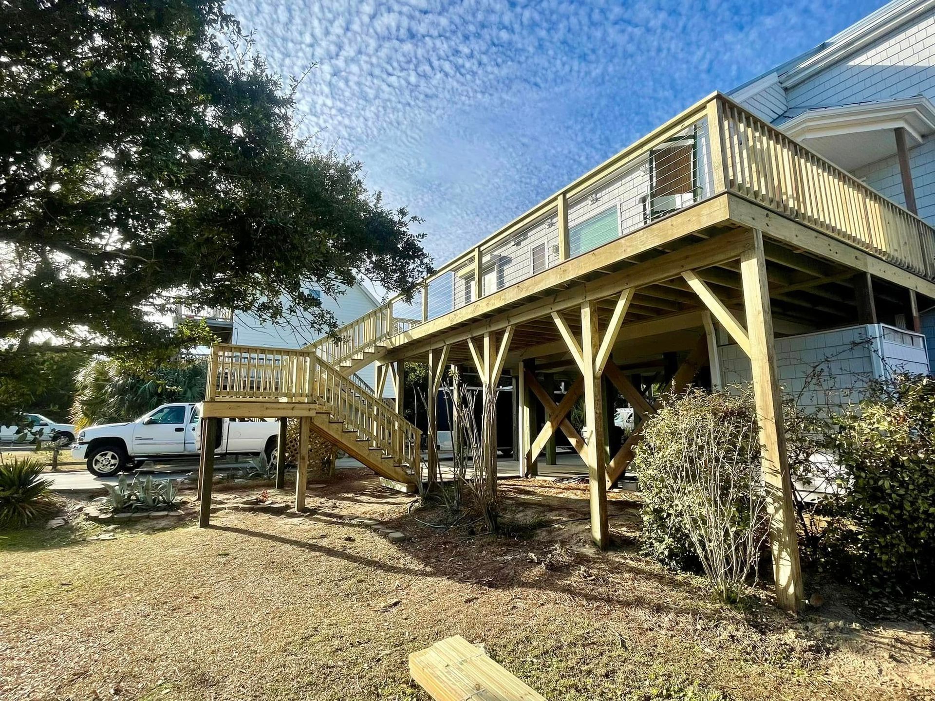 A large wooden deck is being built on top of a house.