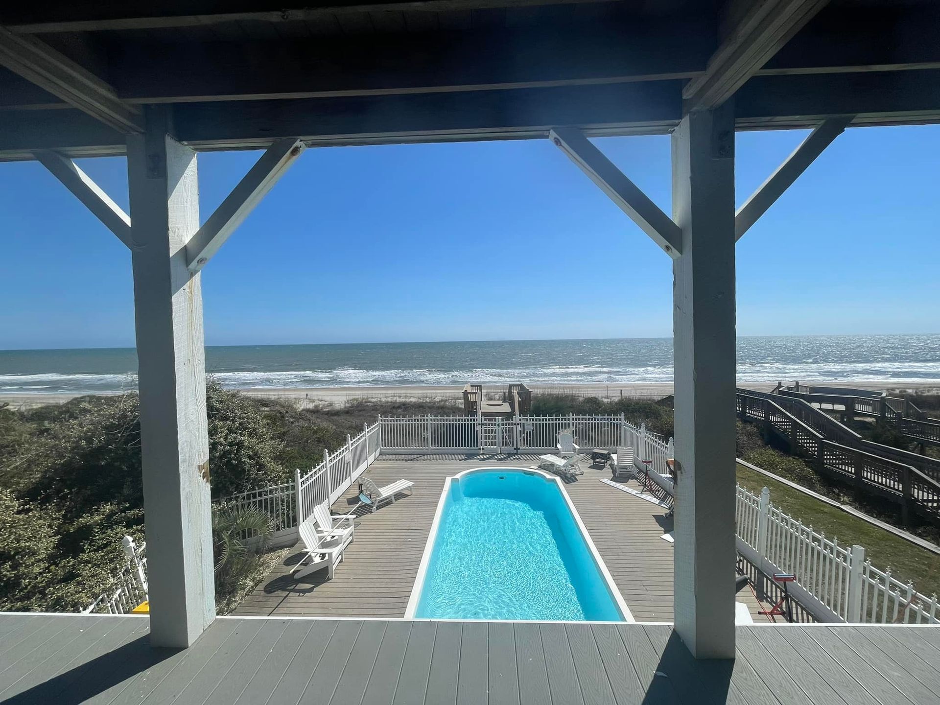 A view of the ocean and a swimming pool from a deck