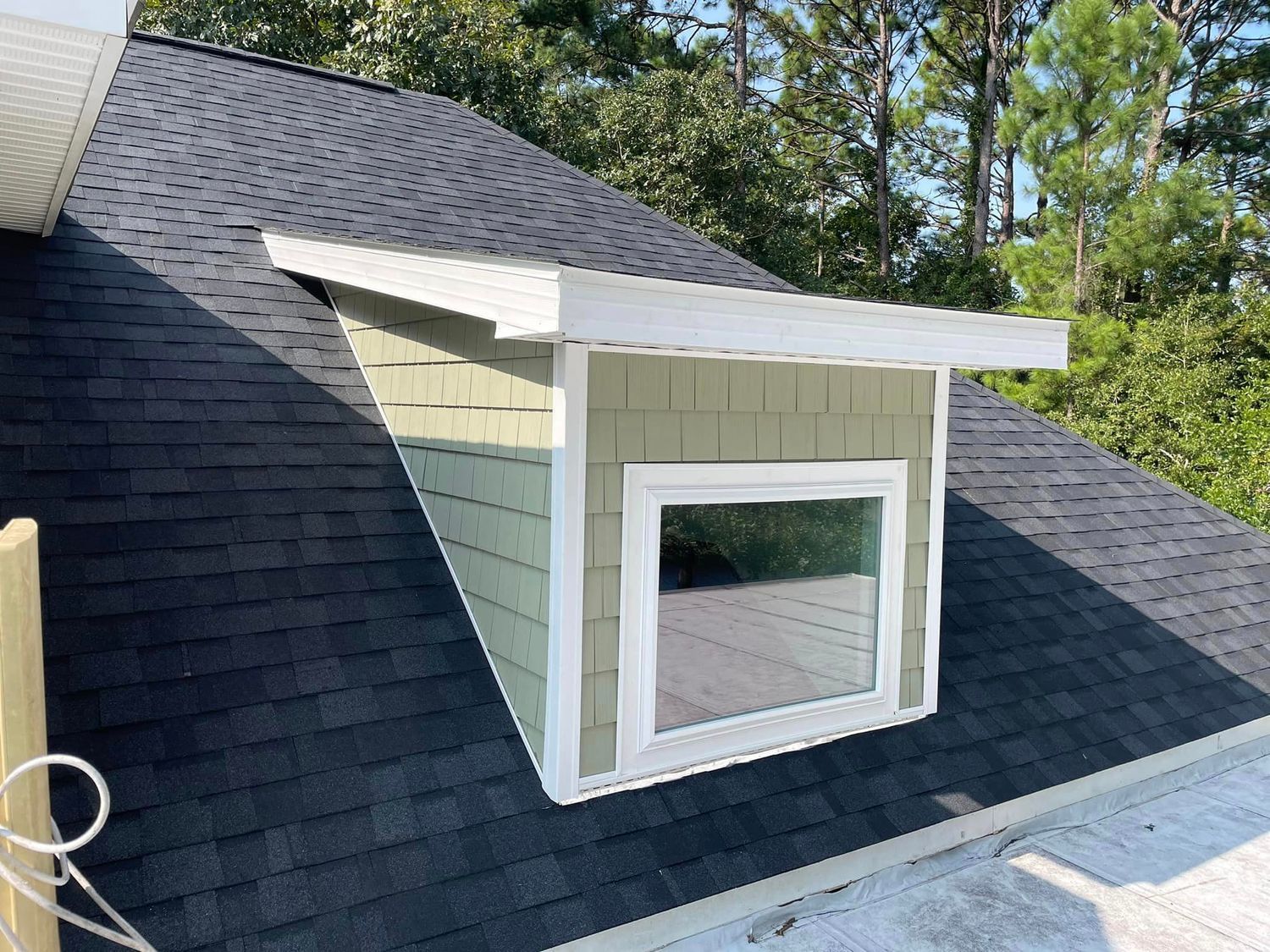 There is a window on the roof of a house.