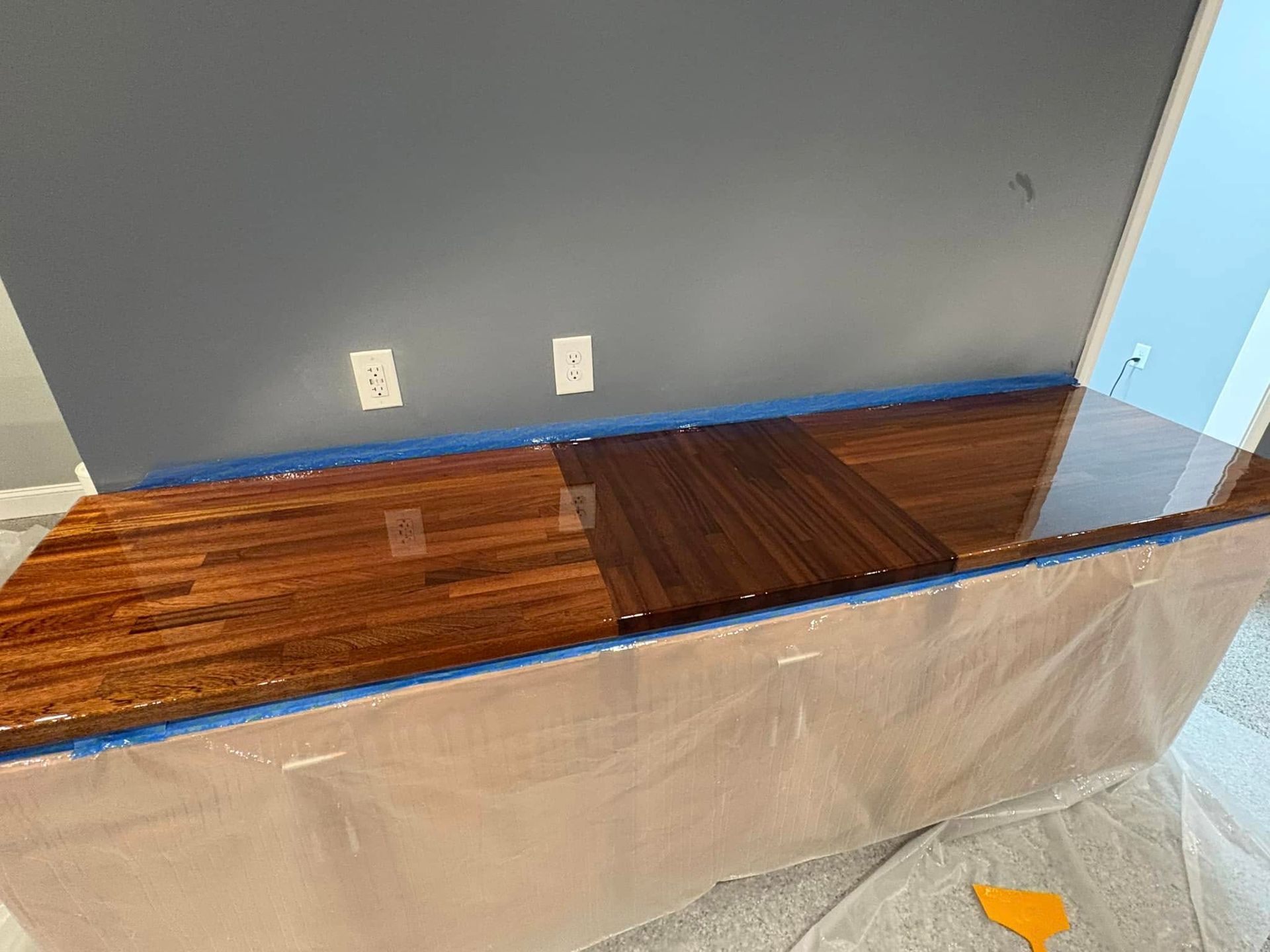 A wooden table is being painted in a room.