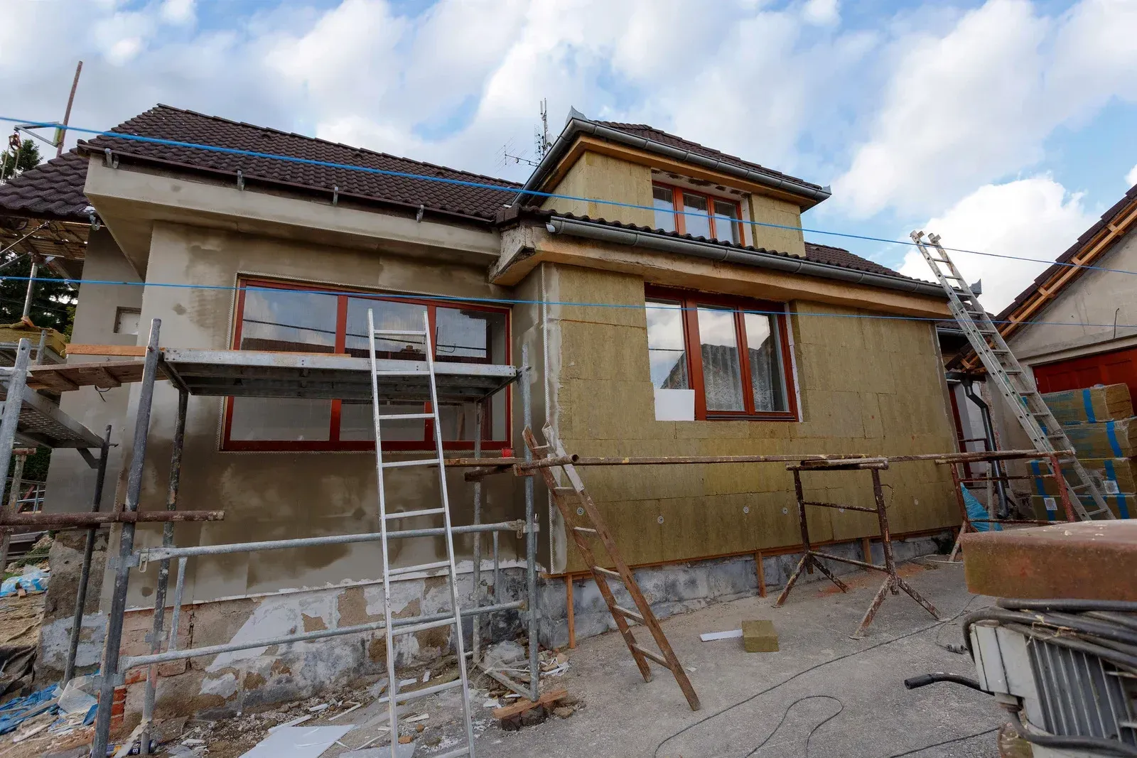 A house is being remodeled with scaffolding and a ladder.
