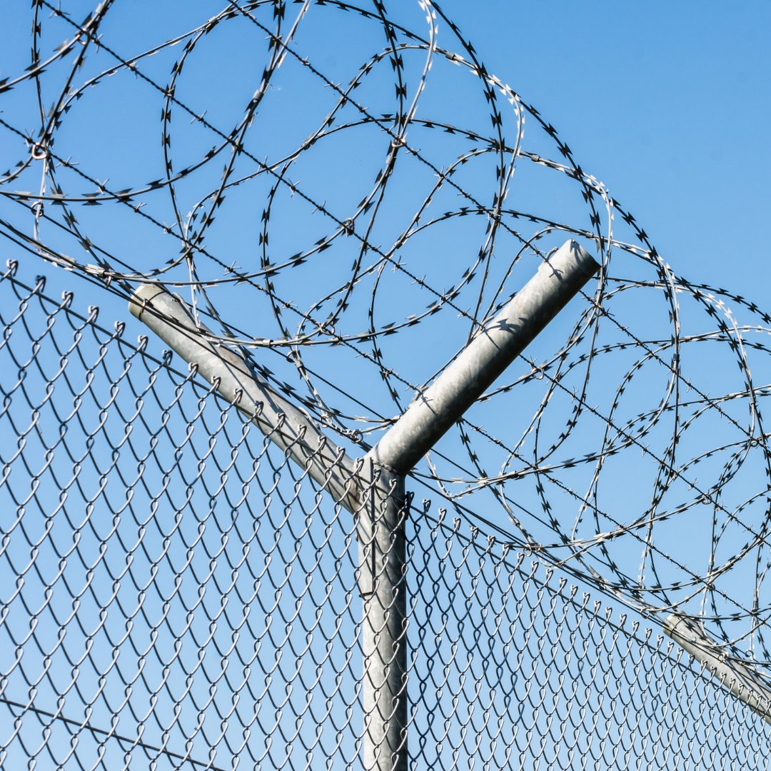 A barbed wire fence with a blue sky in the background