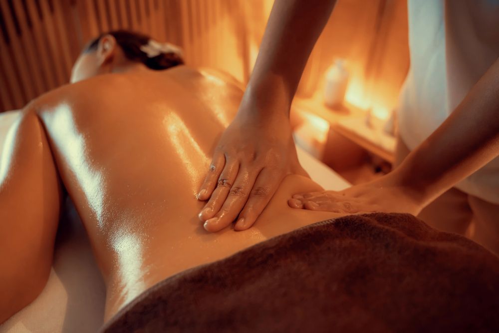 Ambiente de aromaterapia con difusor, difusor de varillas, frascos de aceites esenciales, velas y flores secas.