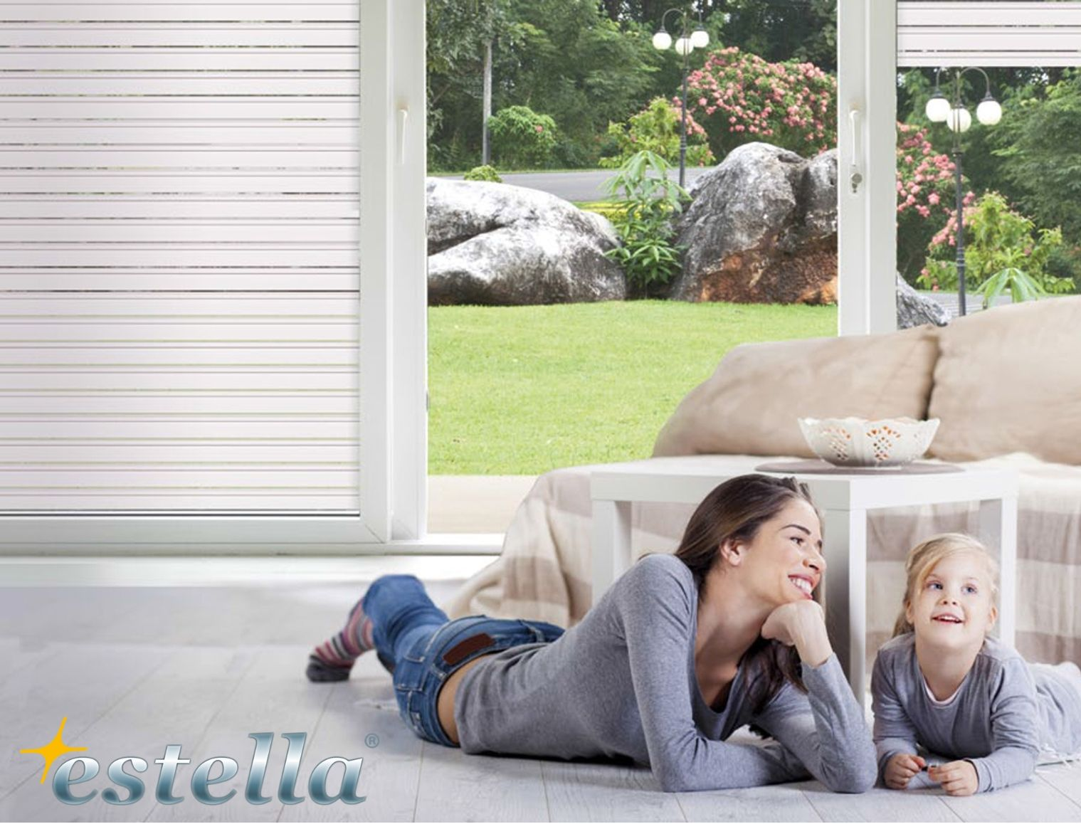 Donna e bambino si rilassano sul pavimento vicino alla finestra aperta, ammirando il panorama esterno.