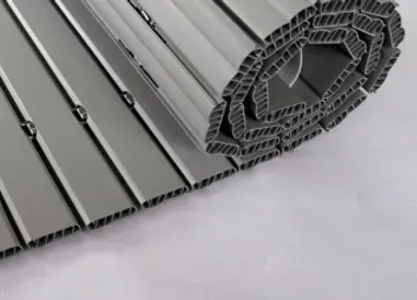 Una tapparella beige chiusa copre una finestra, incastonata in una parete testurizzata grigio-blu.