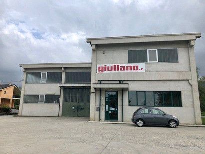 Edificio industriale grigio con insegna 