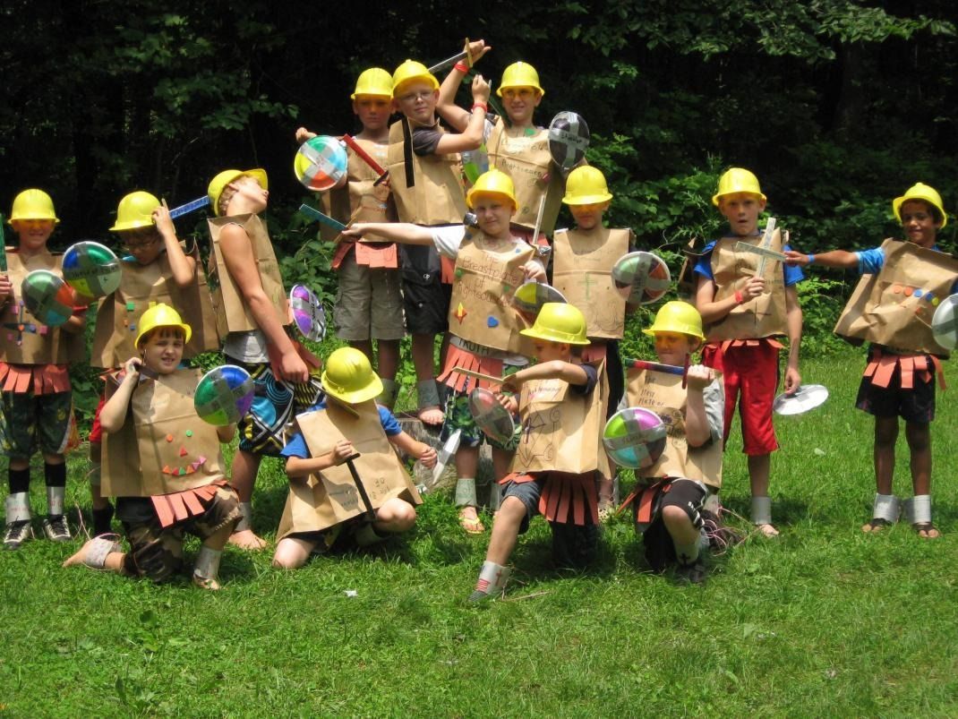A group of children wearing hard hats are posing for a picture