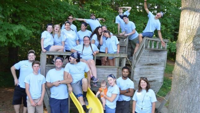 A group of people in blue shirts are posing for a picture.