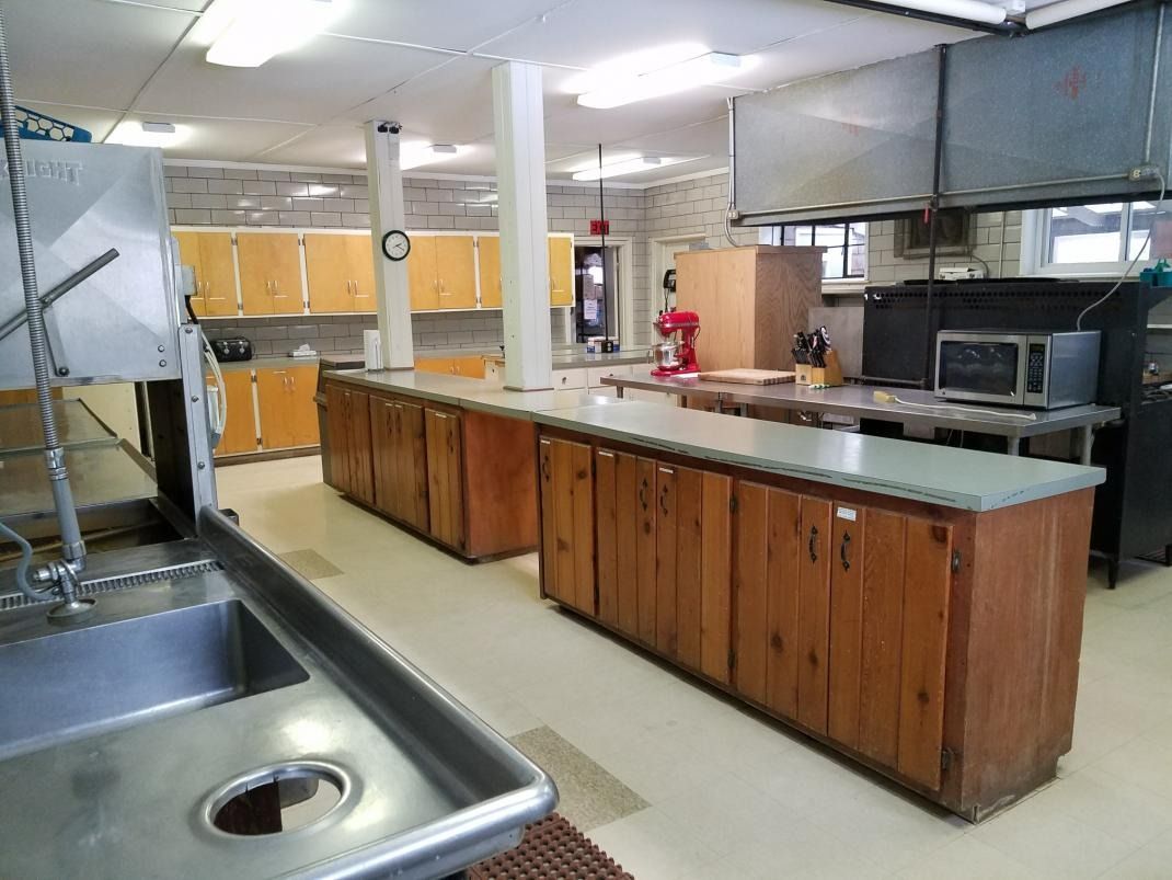 A kitchen with wooden cabinets and stainless steel counter tops