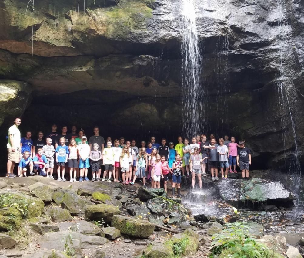 A group of people standing in front of a waterfall
