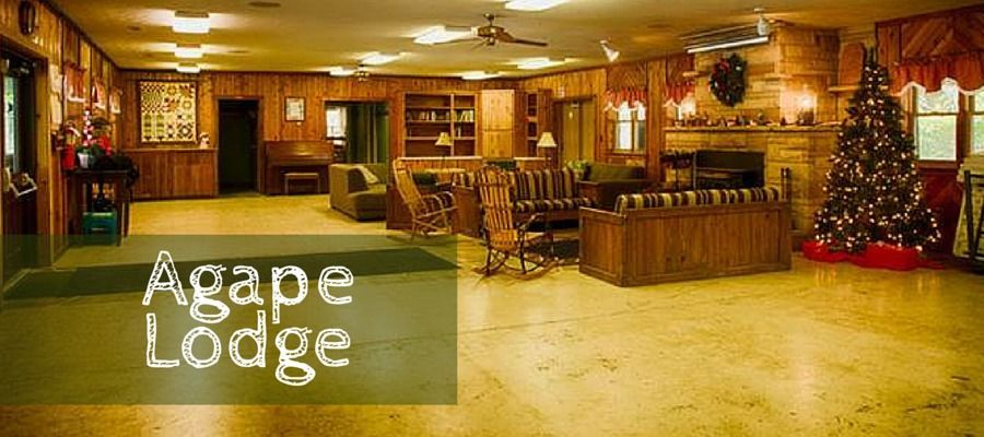 A large room with a christmas tree and a sign that says agape lodge