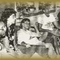 A group of people are sitting around a table in a black and white photo.