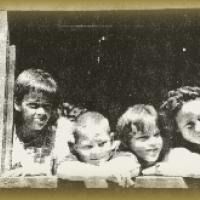 A group of children are looking out of a window.