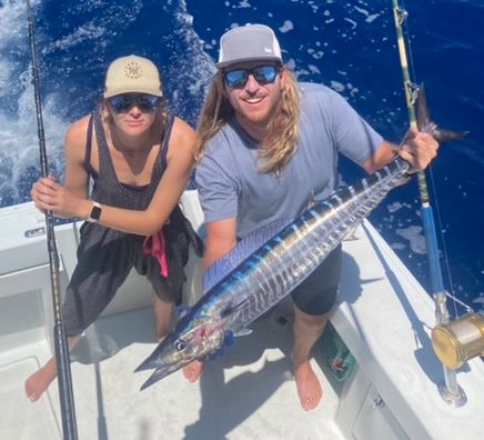 Two men are fishing on a boat and one has a hat that says viper on it