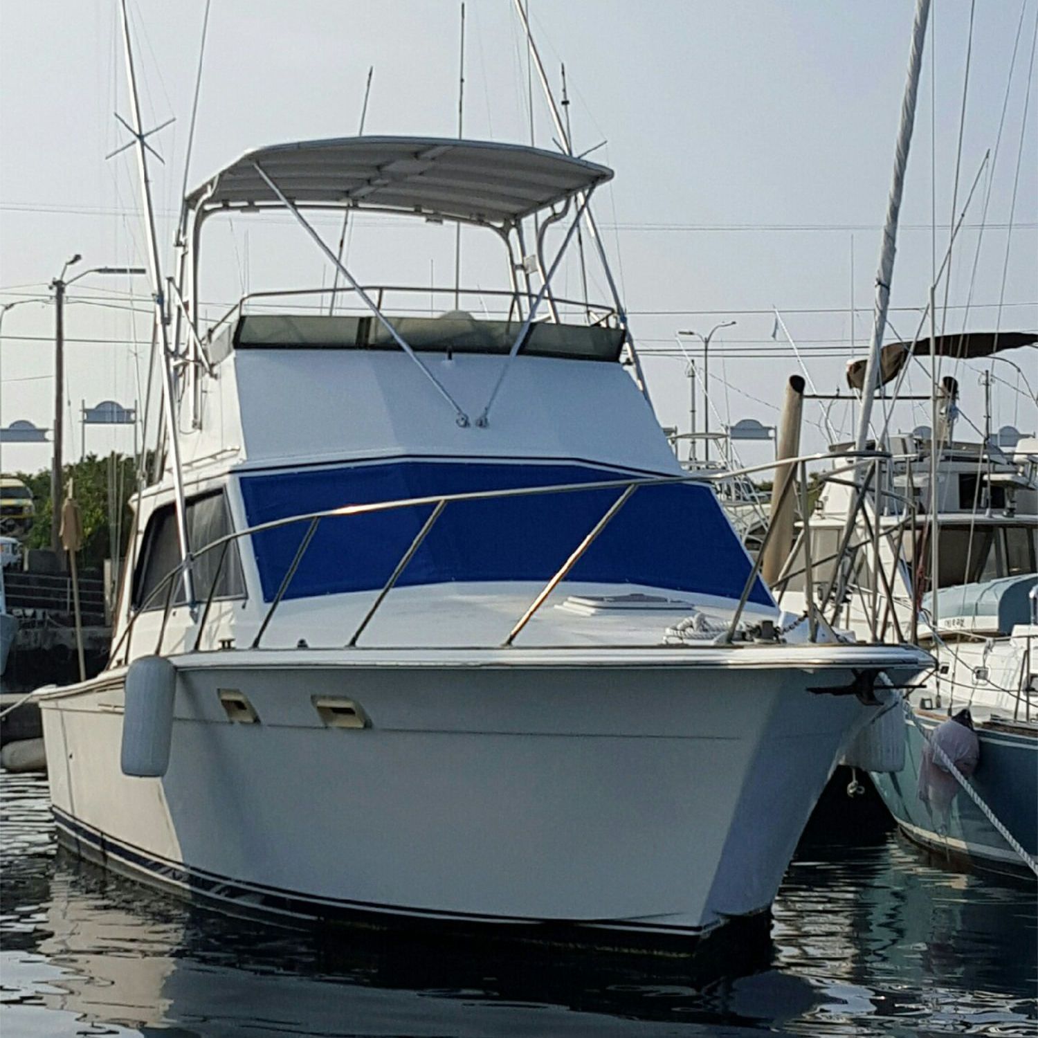 A white boat with a blue windshield is docked in the water
