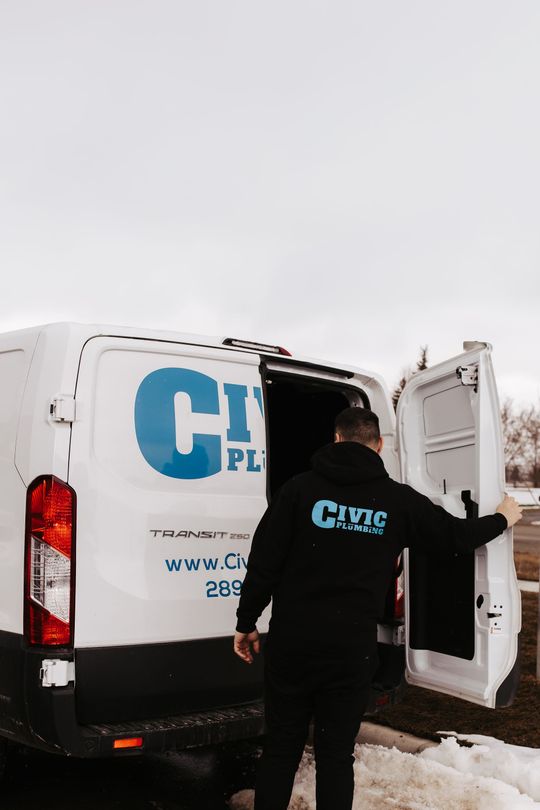 A man opens the back doors of a white Civic Plumbing van under a cloudy sky.