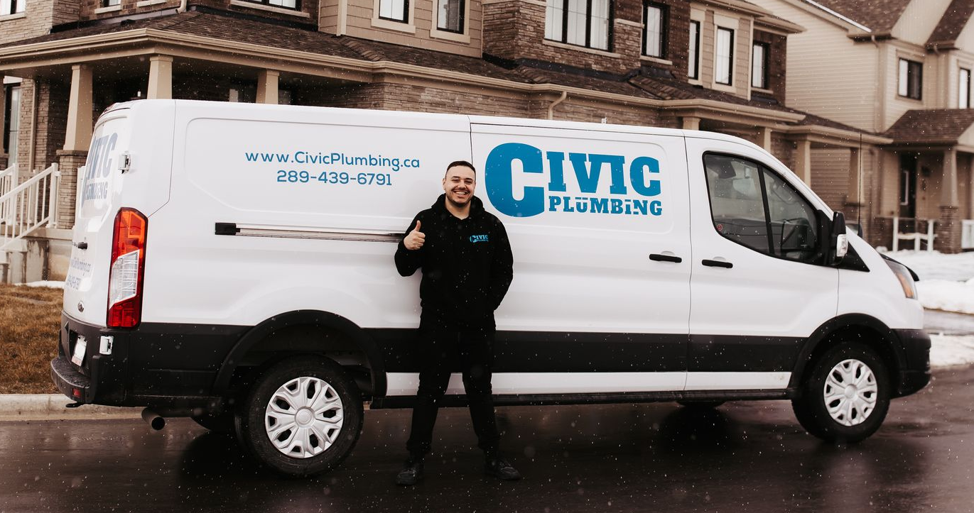 Man in a black hoodie, arms crossed, smiling.