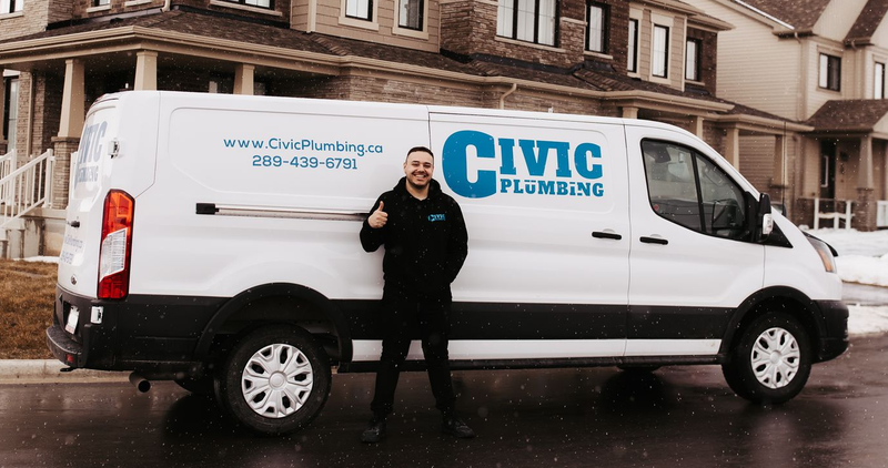 Man in a black hoodie, arms crossed, smiling. 