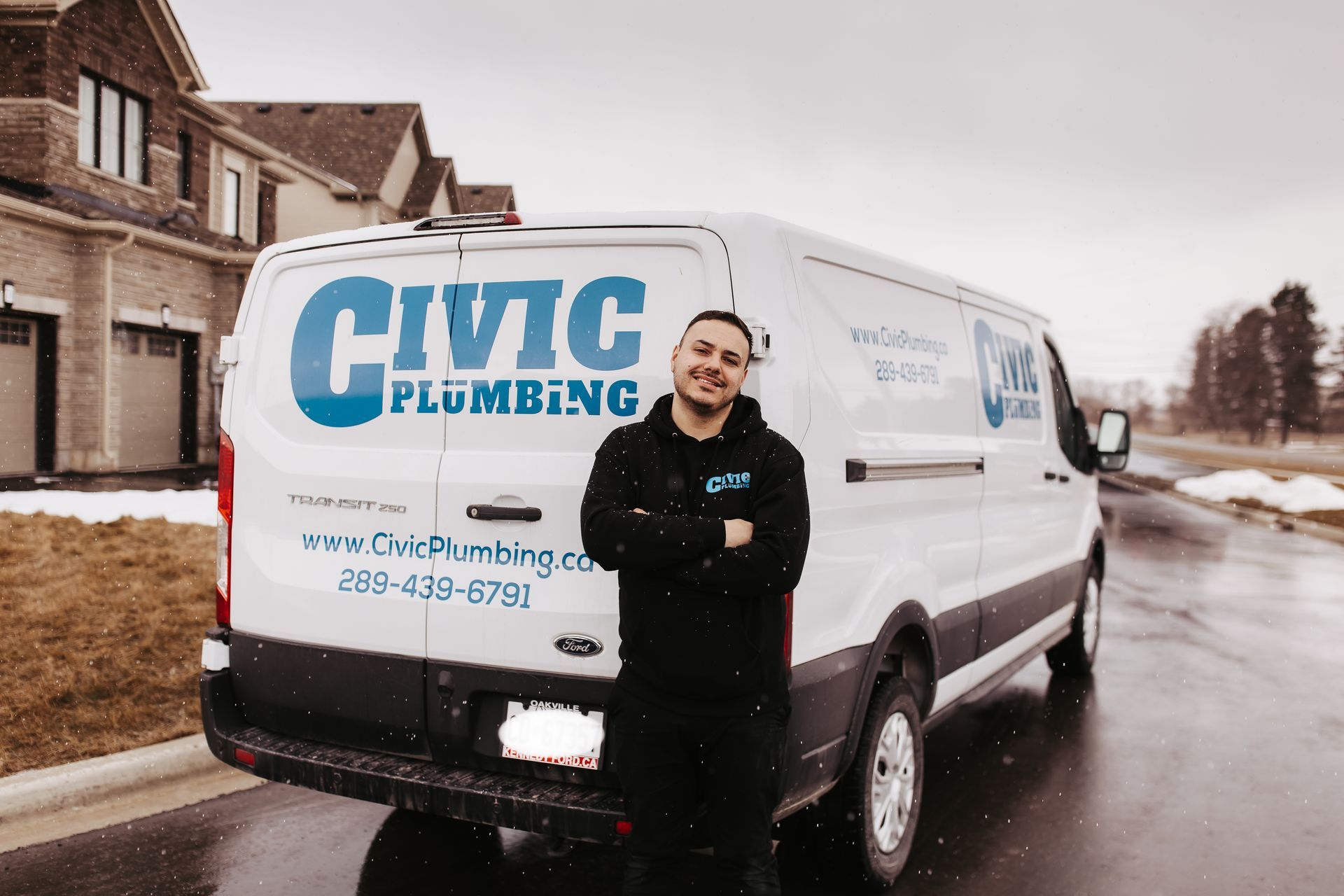 Man in black hoodie stands in front of a white van with 