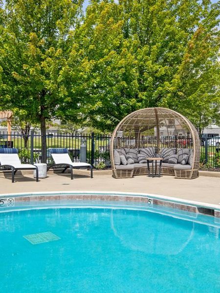A large swimming pool surrounded by chairs and a gazebo at The MilTon, IL.