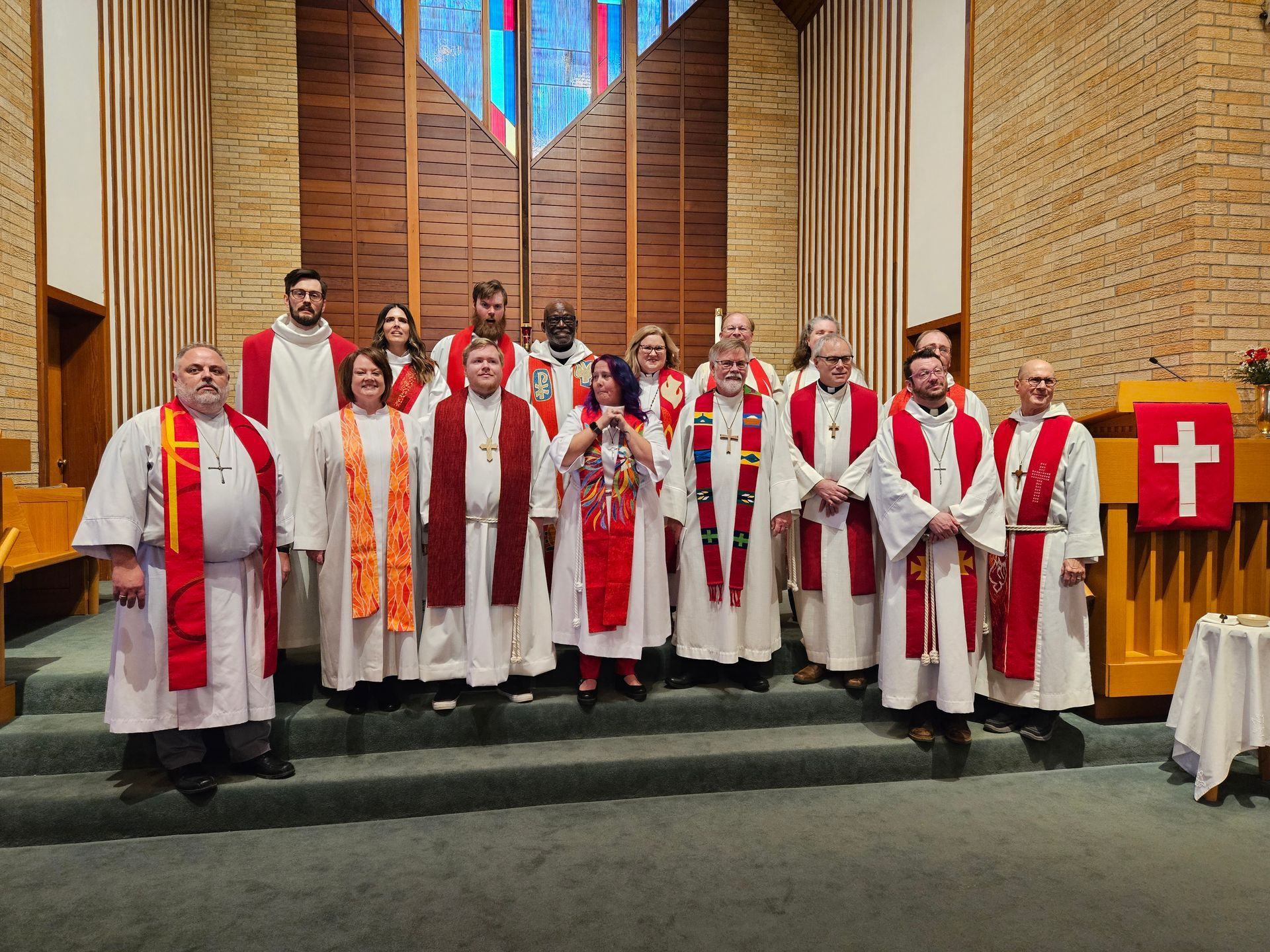 A group of priests are posing for a picture in a church.
