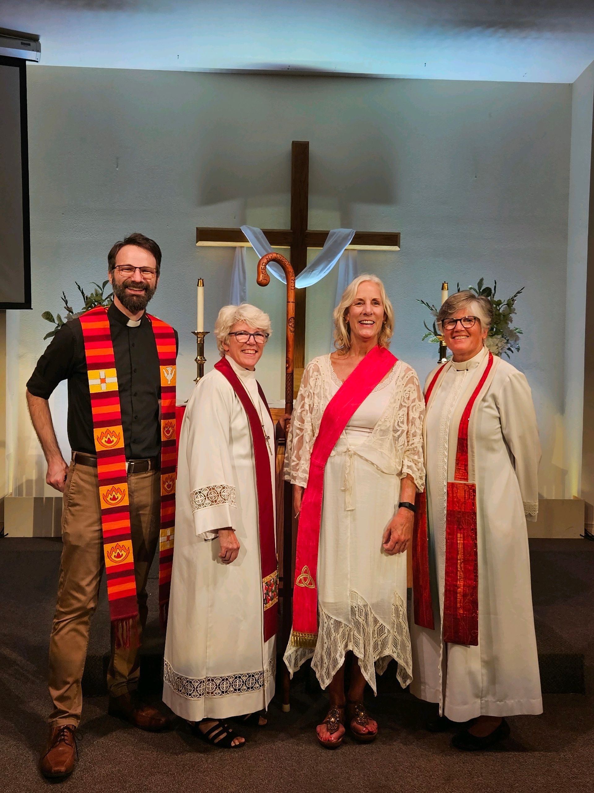 A group of people standing in front of a cross in a church.