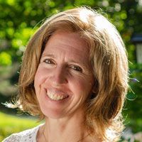 A woman with short blonde hair is smiling for the camera.