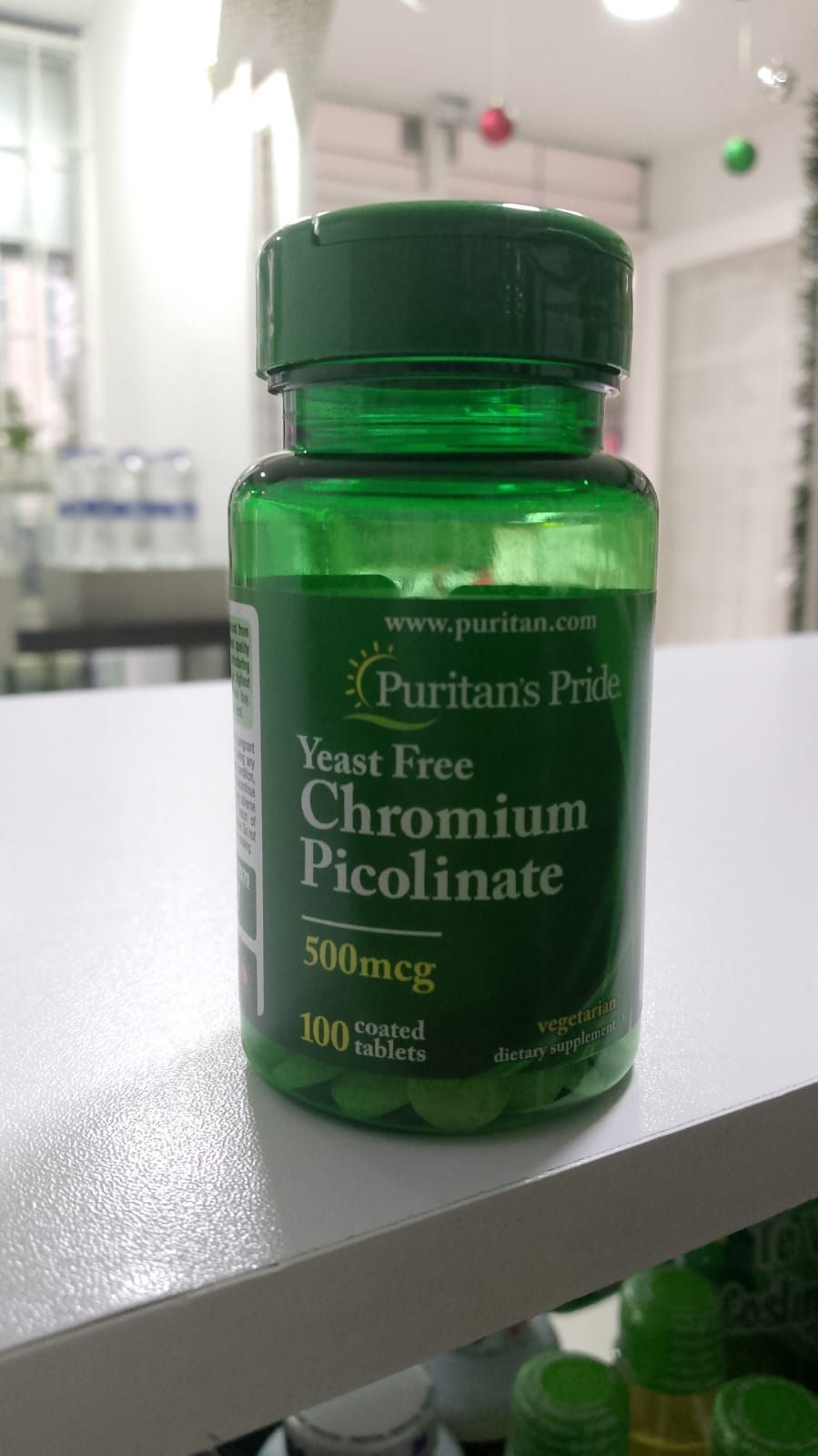 Una botella de picolinato de cromo sin levadura está en un estante.