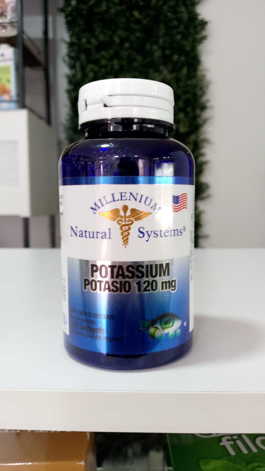 Una botella de potasio 120 mg está sobre una mesa.