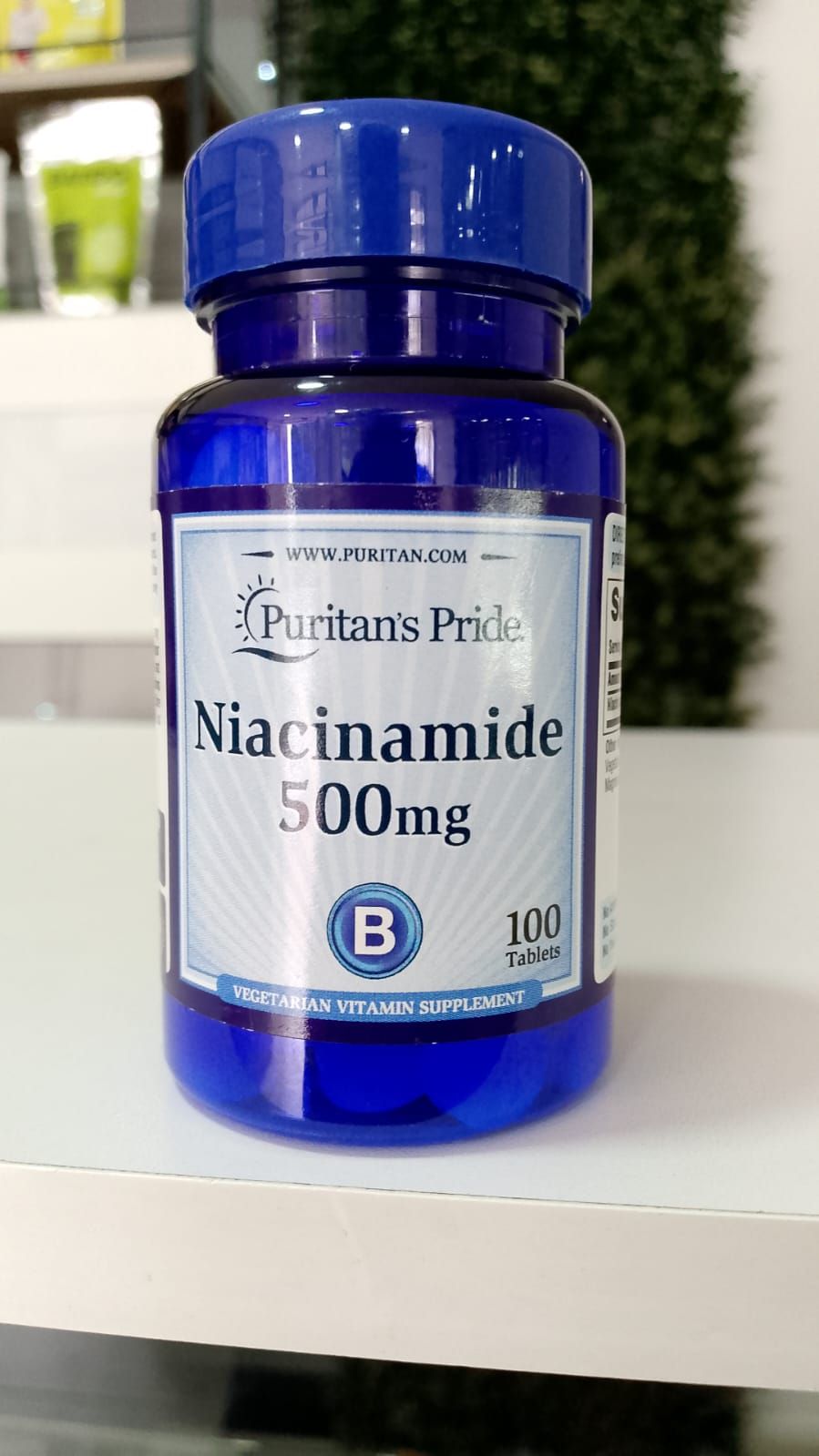 Una botella de niacinamida de 500 mg está sobre una mesa.