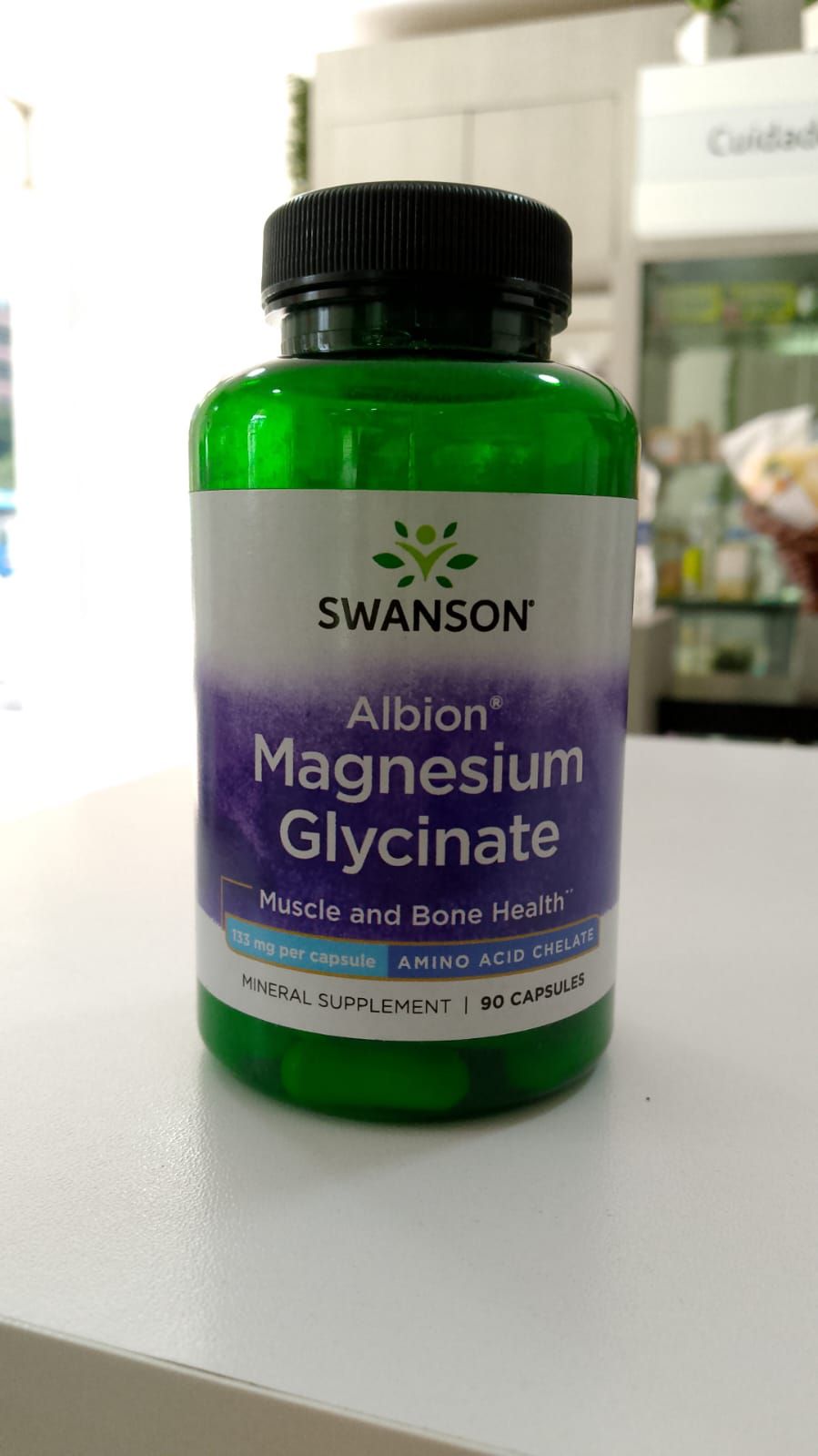 Una botella de glicinato de magnesio Swanson Albion está sobre una mesa.