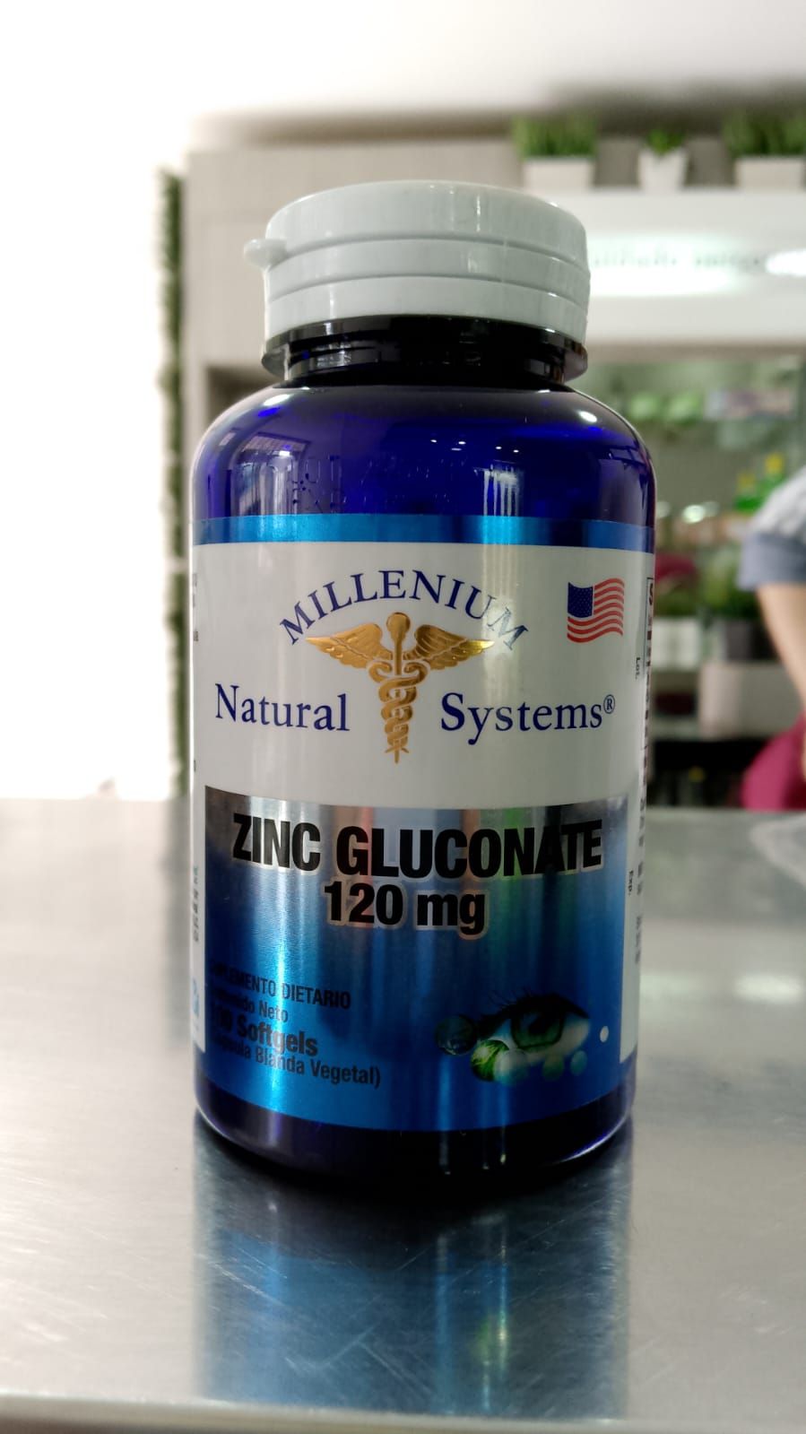 Una botella de gluconato de zinc de 120 mg está sobre una mesa.