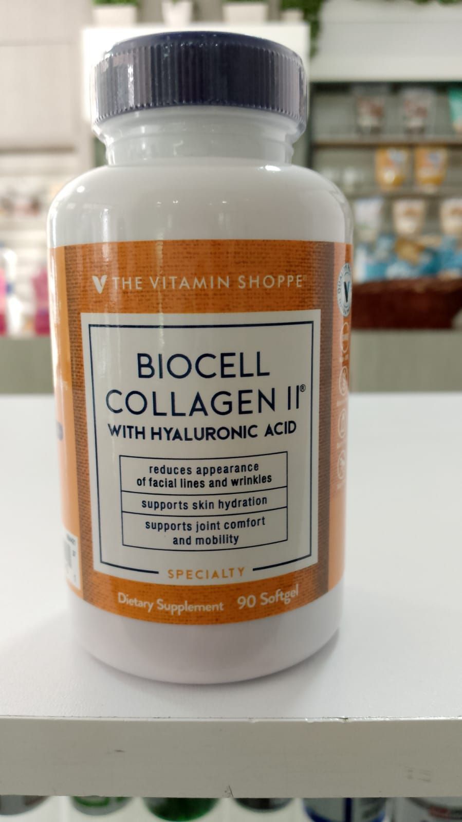 Una botella de Biocell Collagen II con ácido hialurónico está en un estante de una tienda.