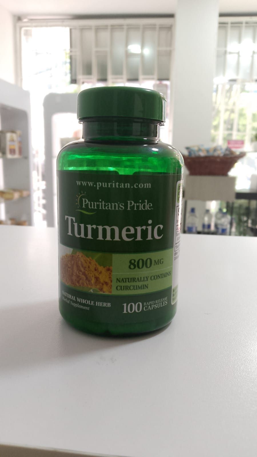 Una botella de pastillas de cúrcuma está sobre una mesa.