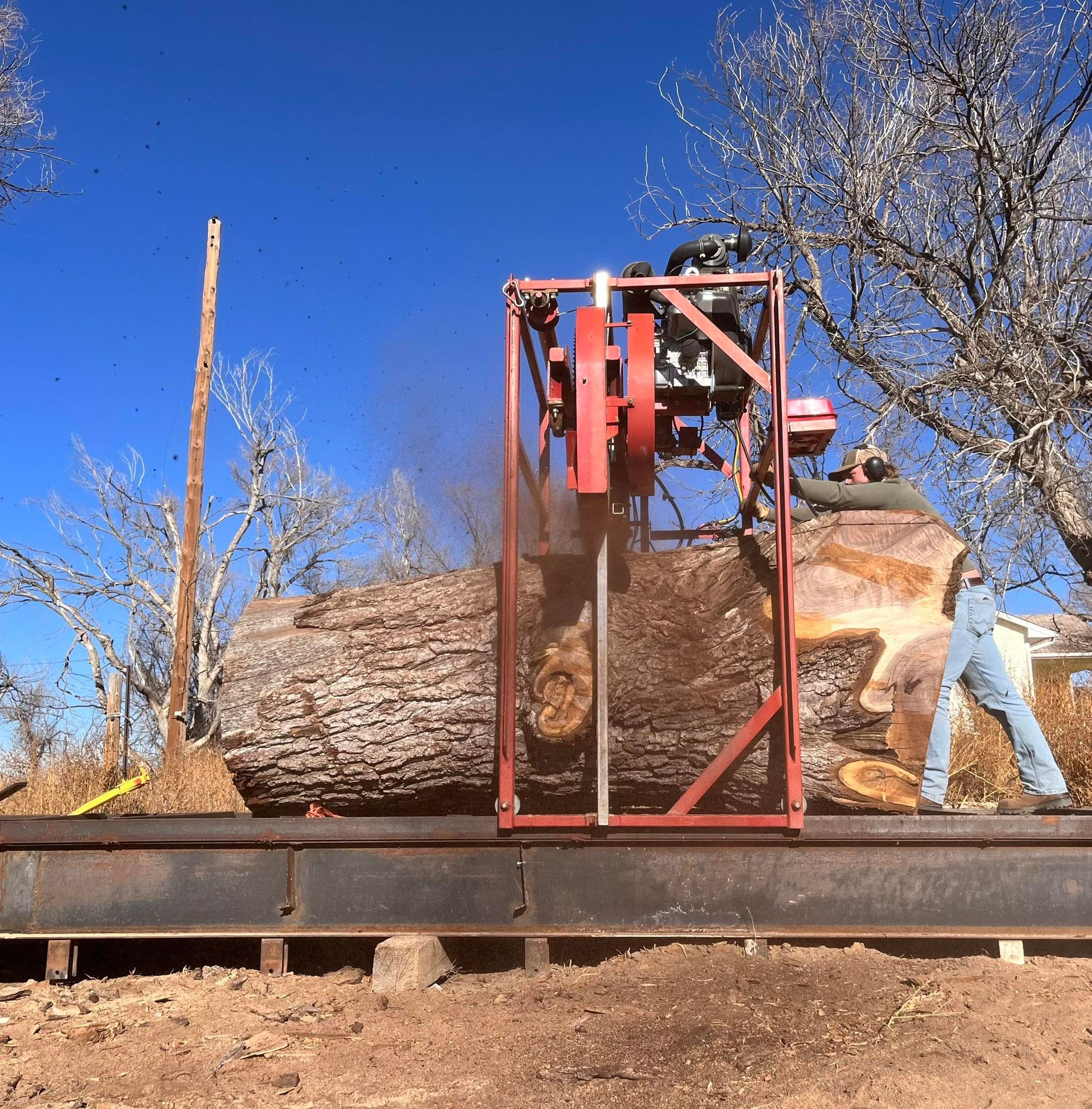 A large log is being cut by a machine