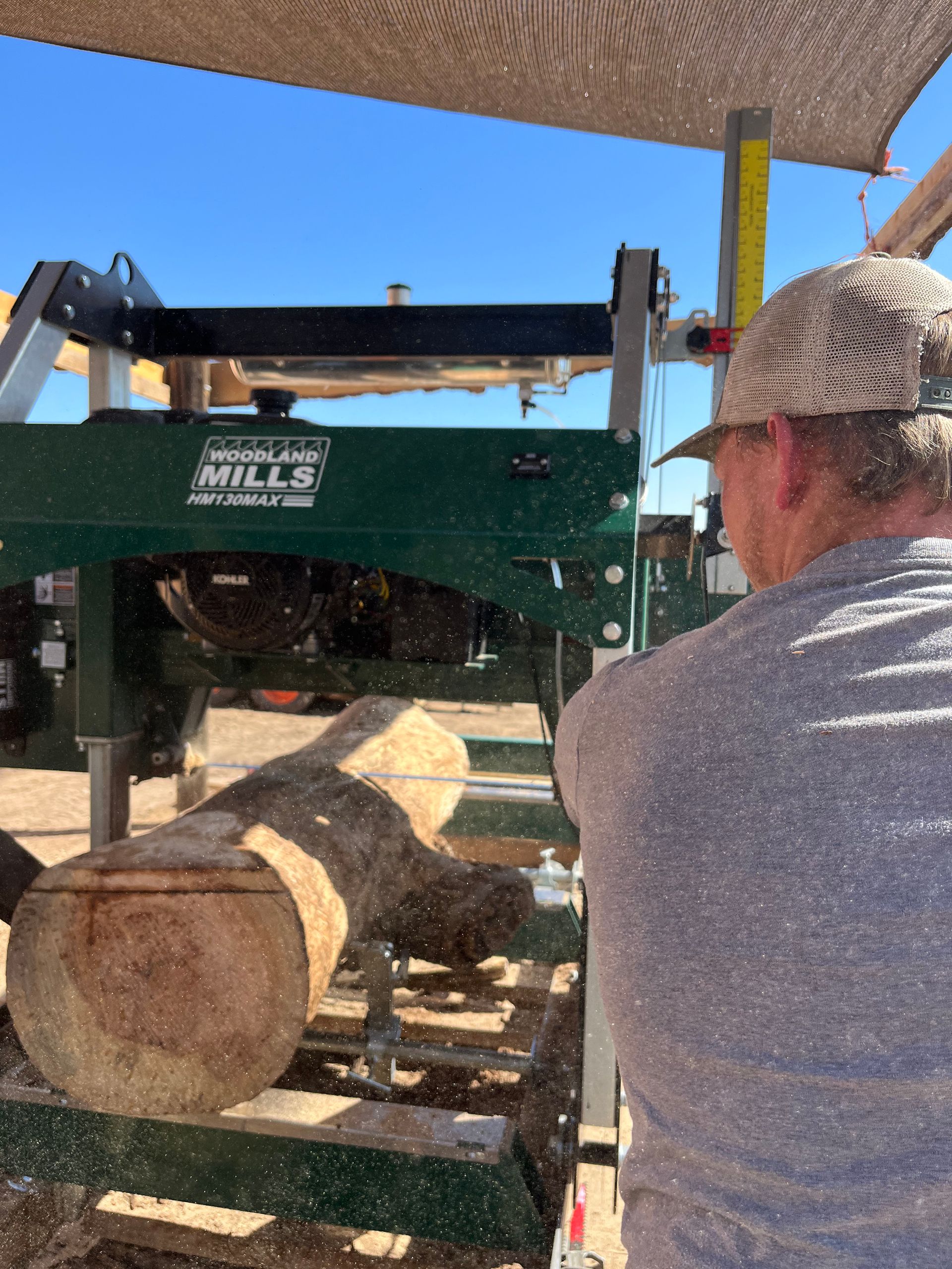 A large log is being cut by a machine
