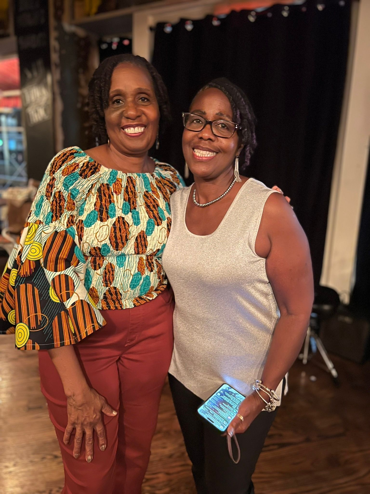Two women are posing for a picture together in a room.