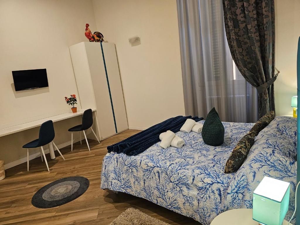 Camera da letto con letto, scrivania e armadio. La stanza ha una finestra con tende.