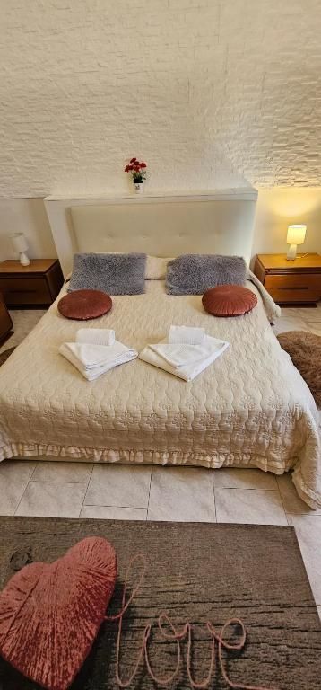 Camera da letto con letto, comodini, cuore decorativo e la parola