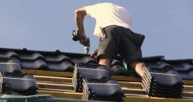 Man re-installing roof systems in Newcastle