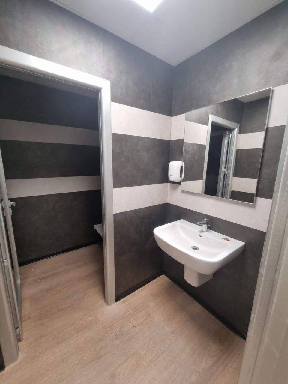 bagno con rivestimenti murali grigi e bianchi in PVC