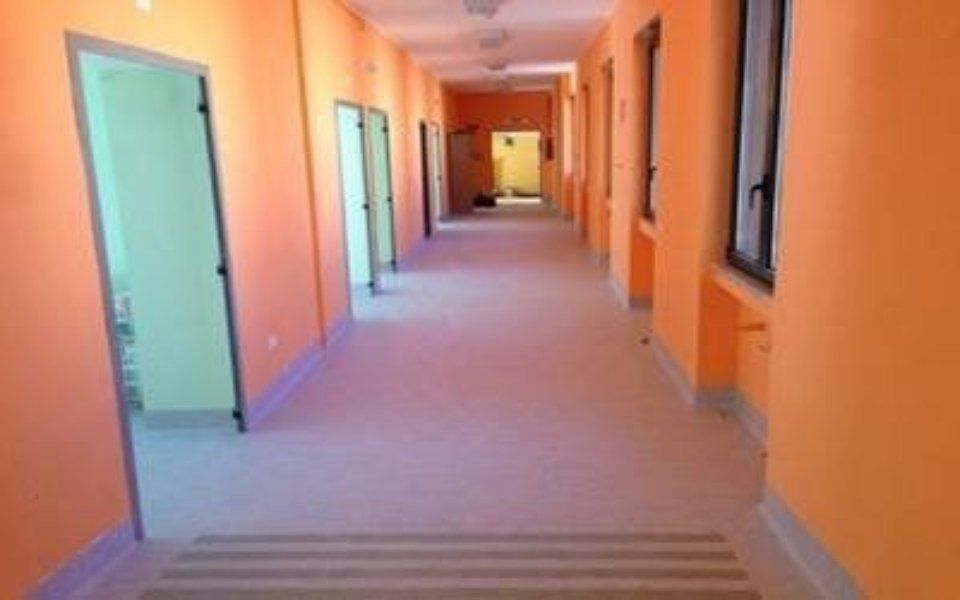 corridoio con pavimento in gomma e pareti arancioni