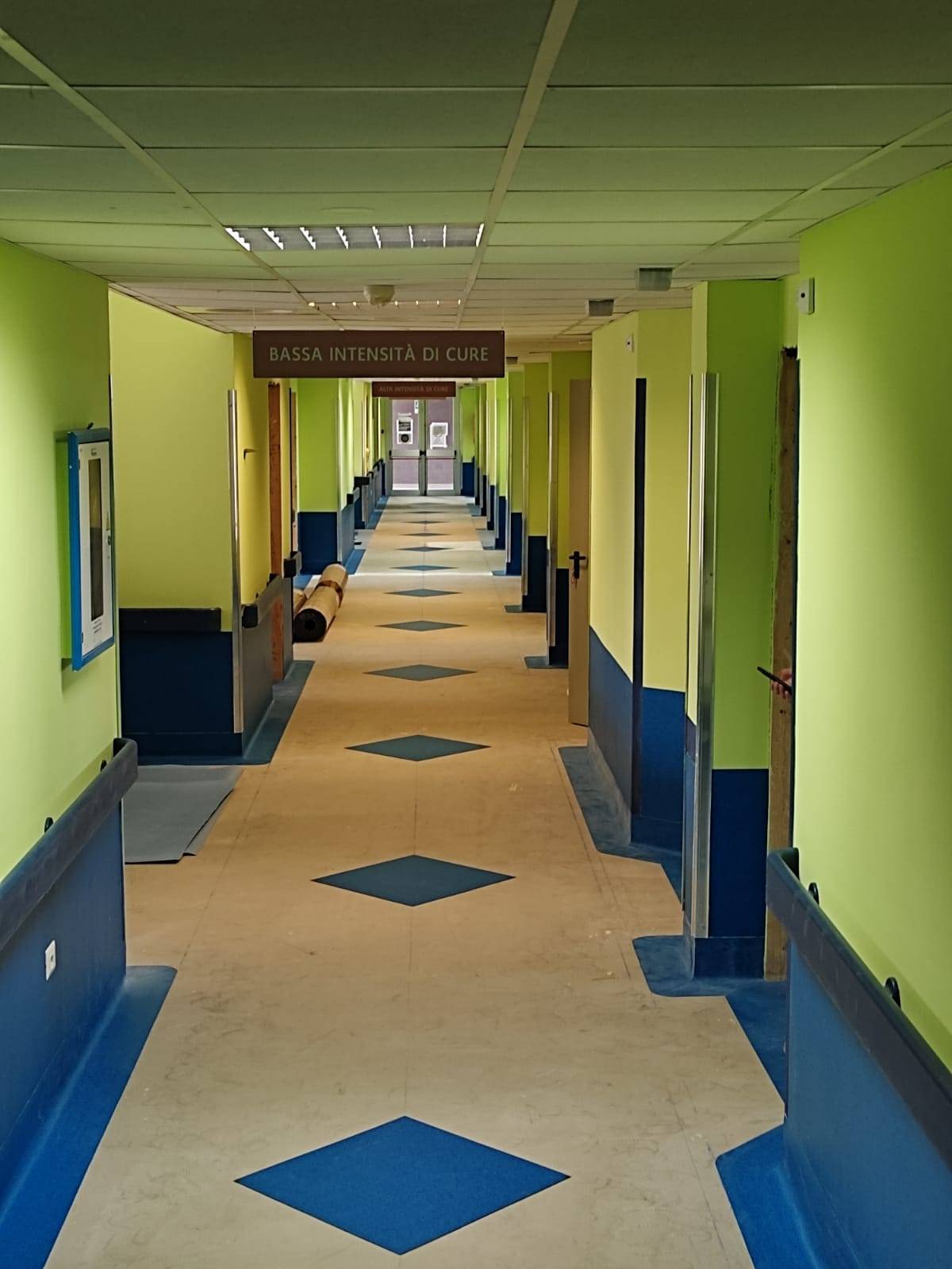 corridoio con pavimento in linoleum beige e rombi blu