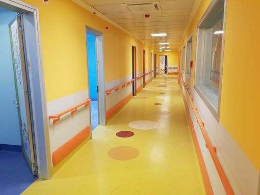 corridoio di struttura sanitaria con pavimento in linoleum giallo