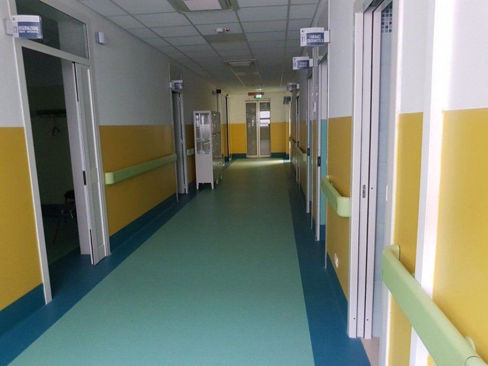 corridoio di un ospedale con pavimento in linoleum verde acqua