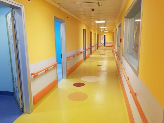 corridoio di struttura sanitaria con pavimento giallo in linoleum