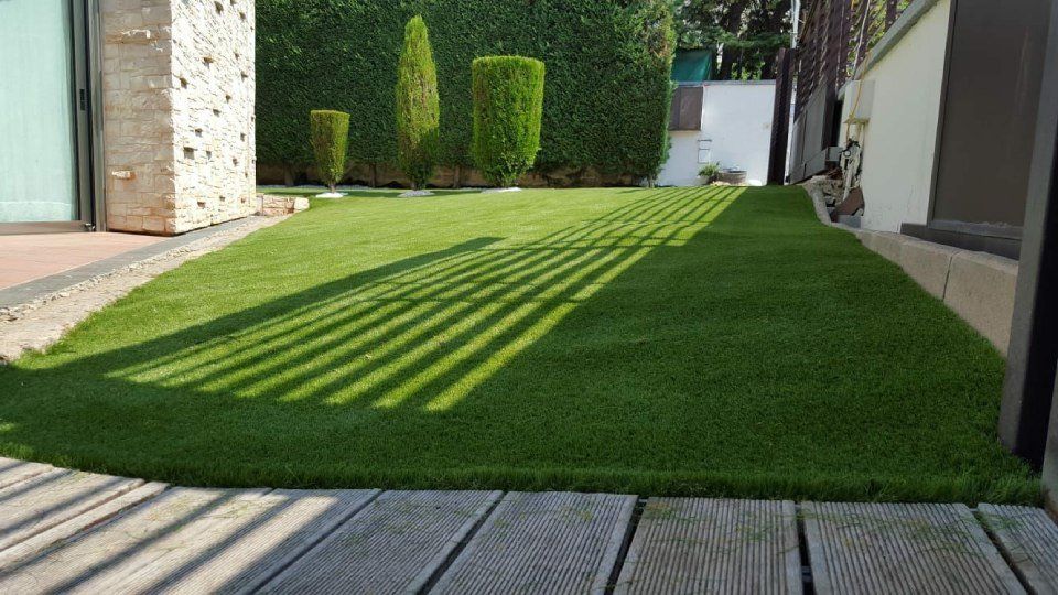 giardino con erba sintetica e alberi